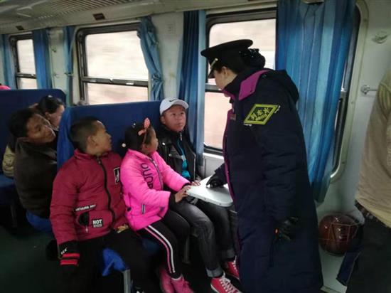列车长阿西阿呷与搭乘“慢火车”的孩子聊天。澎湃新闻记者 廖瑾 图